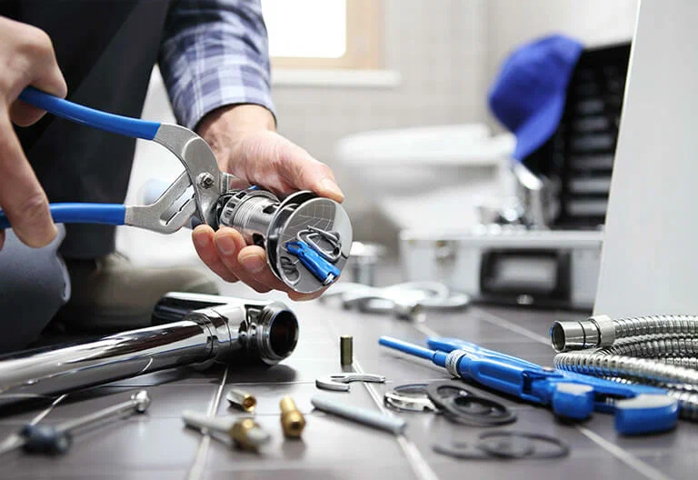 Technician repairing a plumbing fixture with professional tools in Duluth