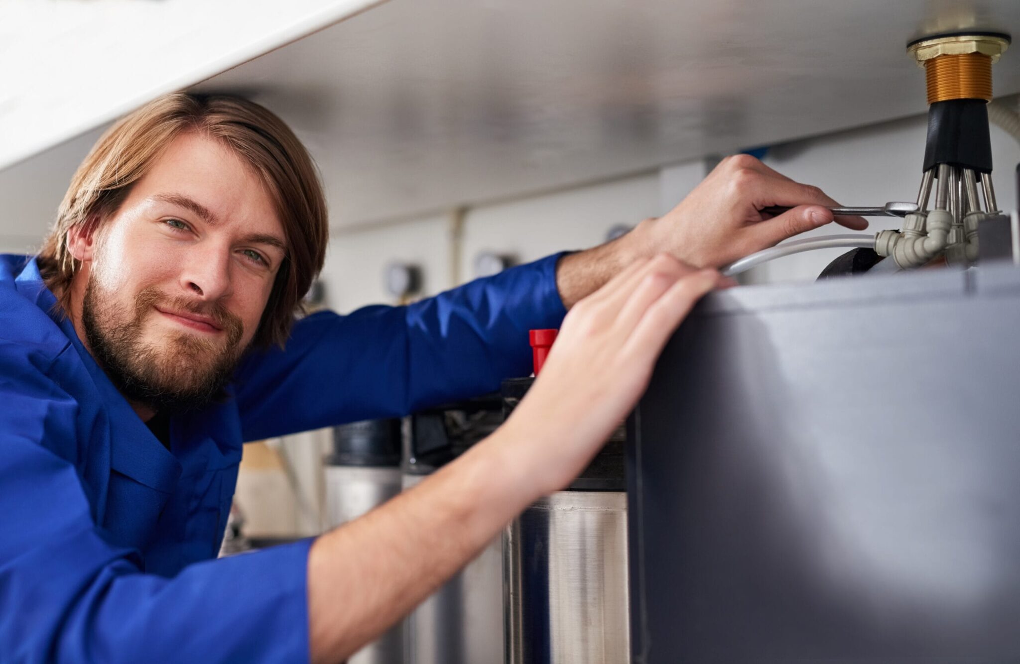 Technician servicing a residential water heater tank in Duluth